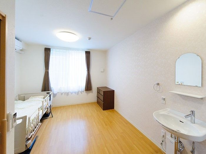 部屋の入り口に洗面台が付いた、大きな窓のあるワンルーム