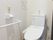 真っ白い壁が印象的なトイレには温水洗浄便座を設置。もちろん手すりや、緊急時用のコールボタンも装備するなど、安心・安全の仕組みも整っている。