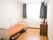 窓からの陽光で明るい部屋である。手すり付きのベッドが置かれている。壁にはエアコンが取り付けられている。