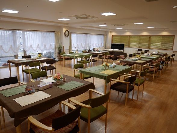 テーブルクロスがかけられた4人掛けのテーブルが並ぶ、広い食堂