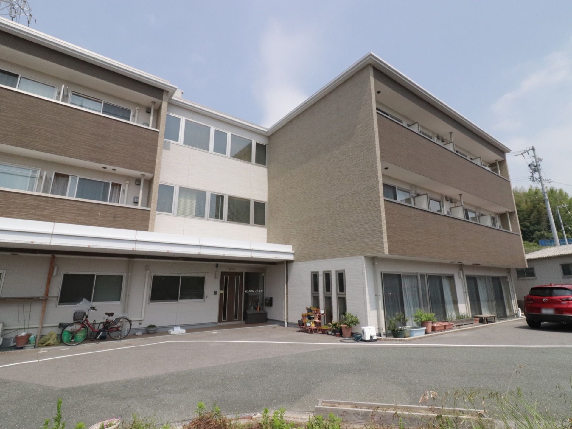 道路から入った横側にエル型の３階建ての建物がある。日当たりも良く、自然豊かな環境に恵まれた施設である。