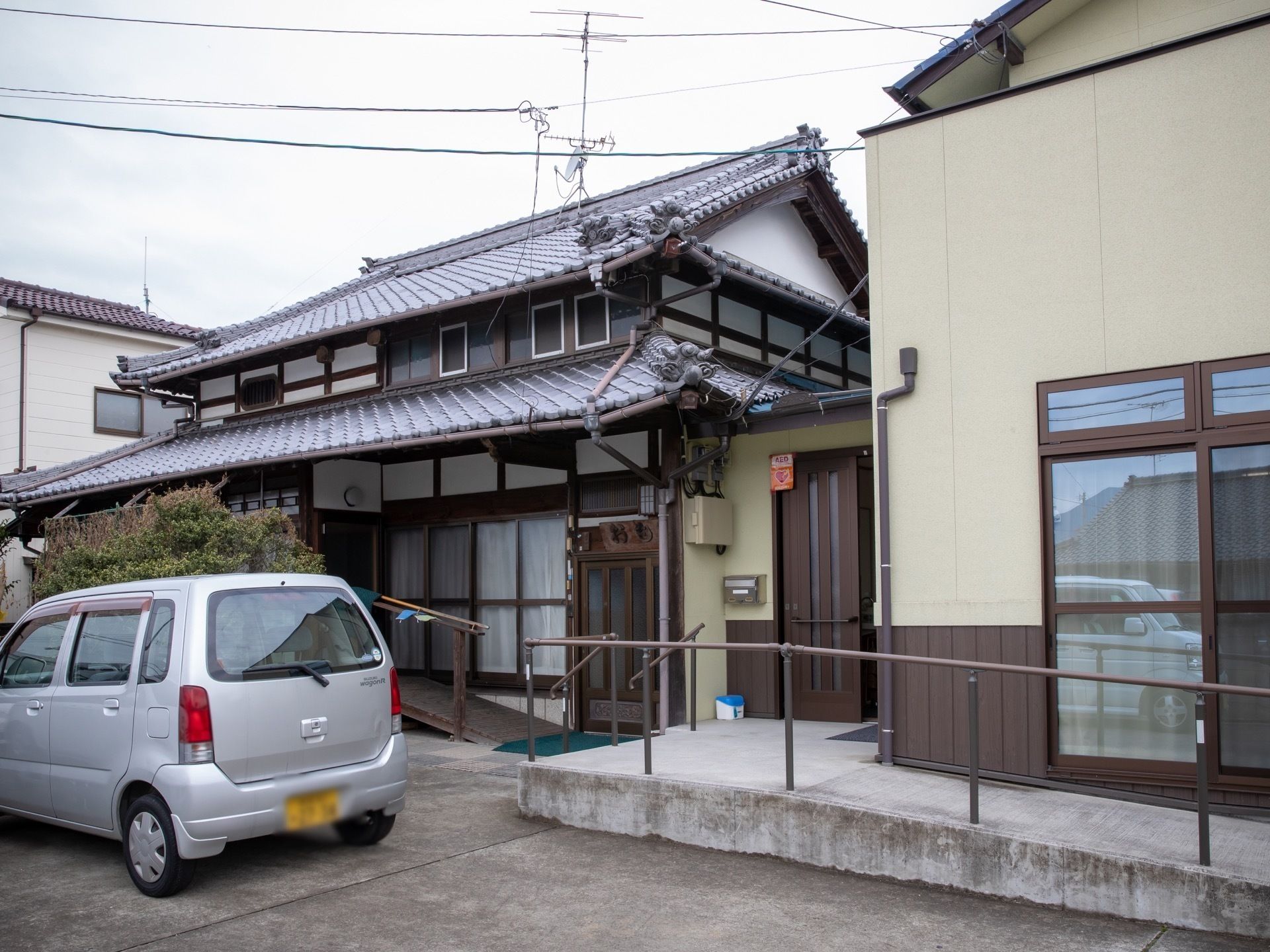 玄関の前が手すりのあるスロープになっている日本家屋