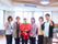 リビングを背景に、六人の男女のスタッフが笑顔で写っている。マスコットキャラクターのぬいぐるみを持っている。