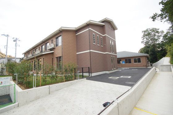 緩い坂道を上がった所に建てられた、茶色いタイル張りの建物