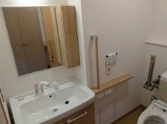 トイレ使用時に立ち座りが行いやすくなるよう、手すりを設置している。また、洗面所とトイレが同じ個室内にあるため、すぐに手洗いができる。
