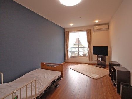 窓の脇にはテレビが置かれ、入り口側に介護ベッドの置かれた部屋