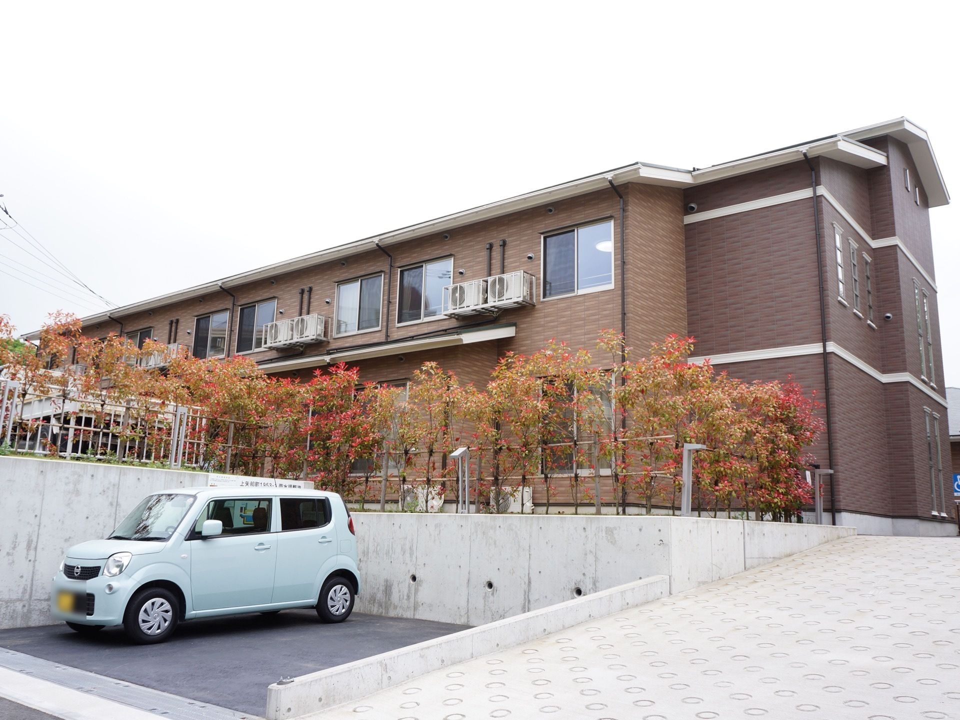 2階建てでブラウン色の建築である。駐車場も設けられ、玄関までは緩やかな坂に造られ、少し高台になっている。