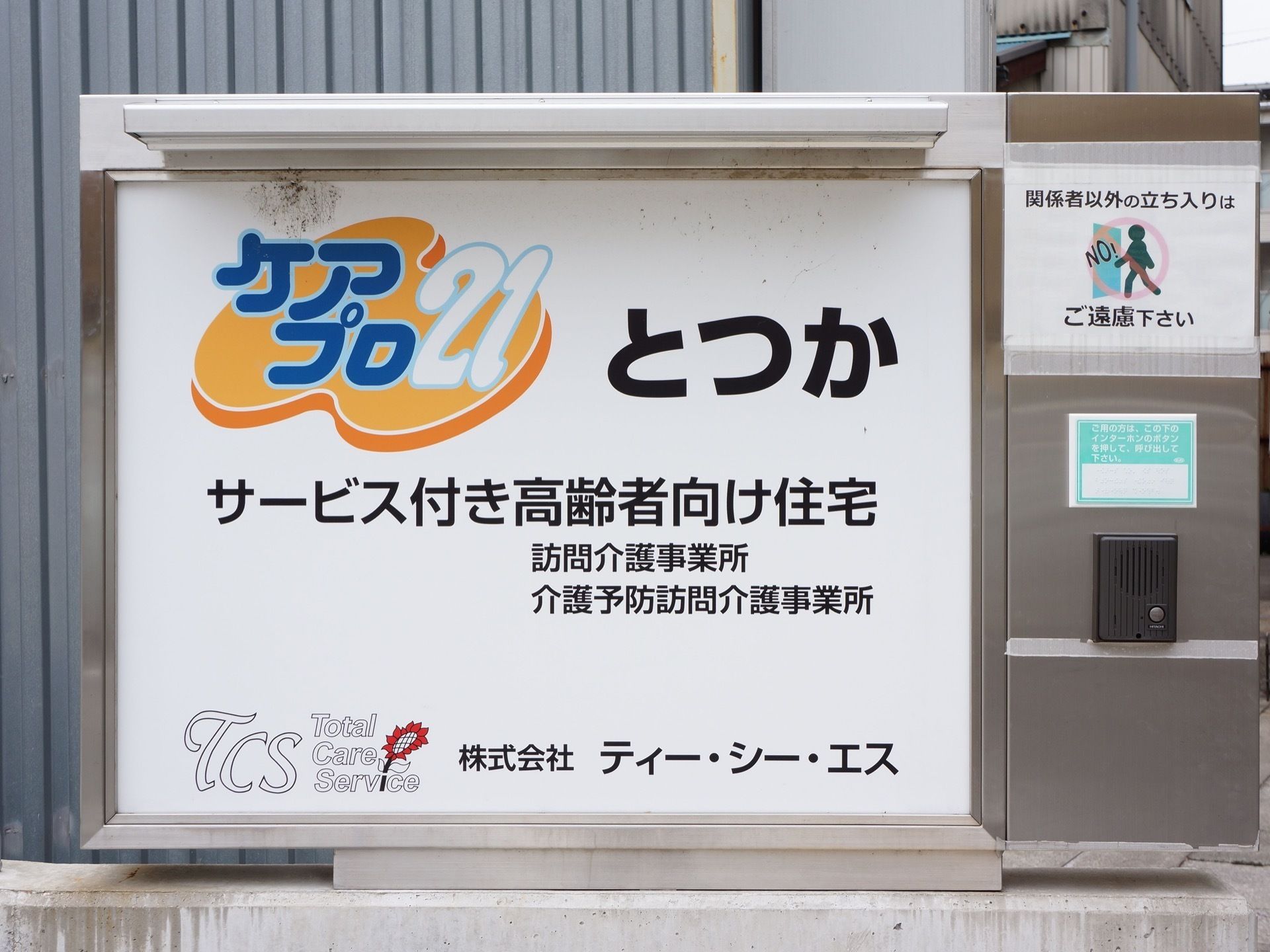 施設敷地の入り口に建てられている看板である。アルミ板にロゴ、施設名、親会社についての情報も書かれている。