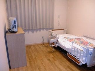 柵のついた介護ベッドが置かれた、フローリング敷きの部屋