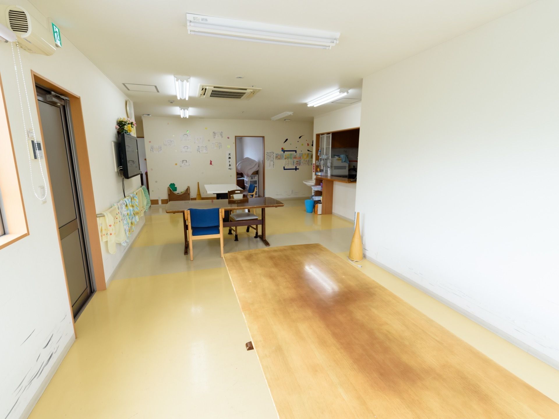 開放的な食堂はレクリエーションホールにもなっている。キッチンが設けられている。テレビや手すりが壁に取りつけられている。