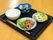 栄養バランスや食べやすさを考えて作られた食事である。入居者様お一人おひとりに黒のトレイで配膳される。