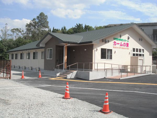 階段か緩いスロープを通って玄関へ入る、平屋建ての建物