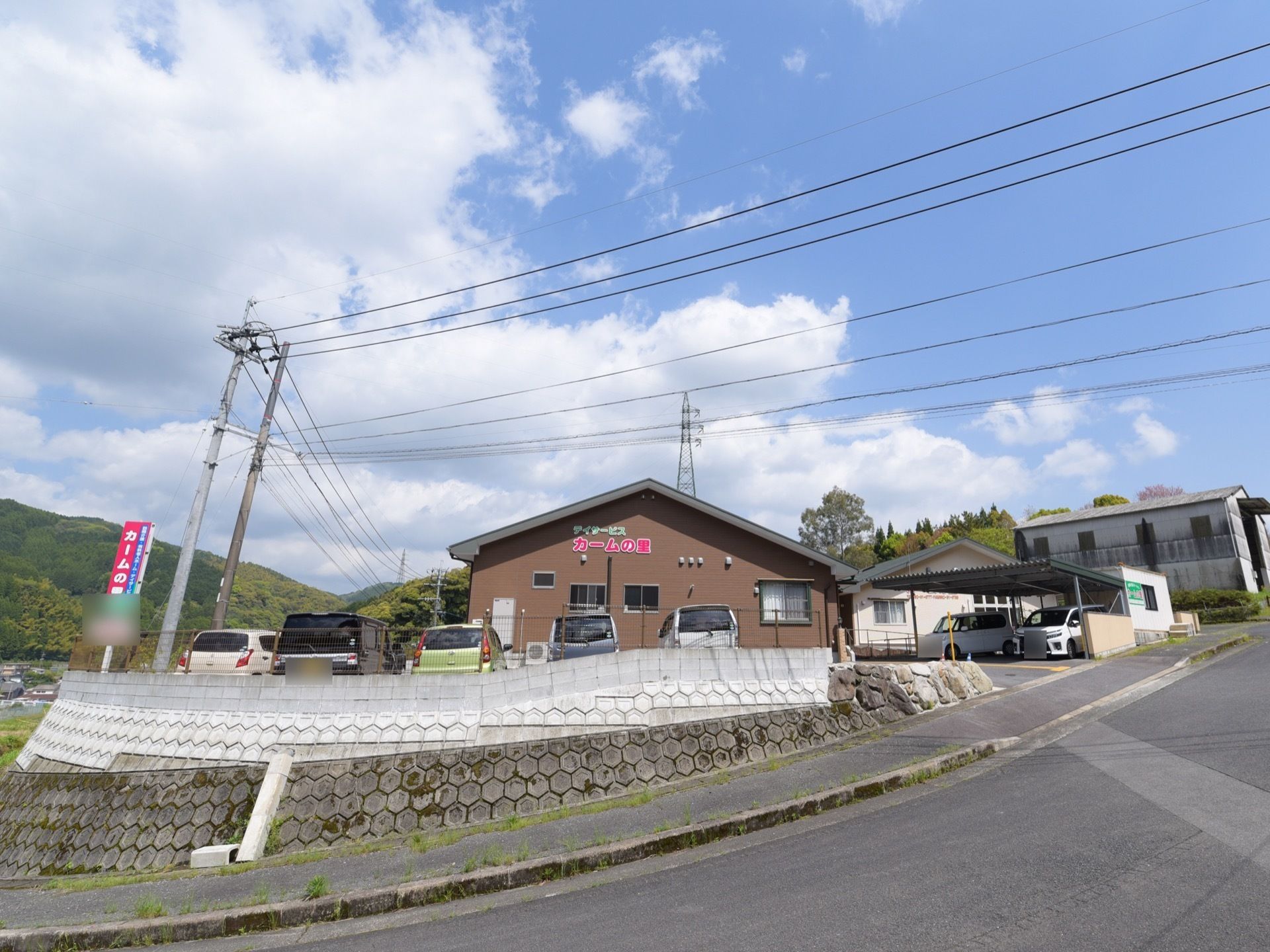 敷地が坂の途中にあるため、土台をしいて地面を平らにした上に建物を建てている。建物周辺は緑に囲まれて自然が豊富な環境。