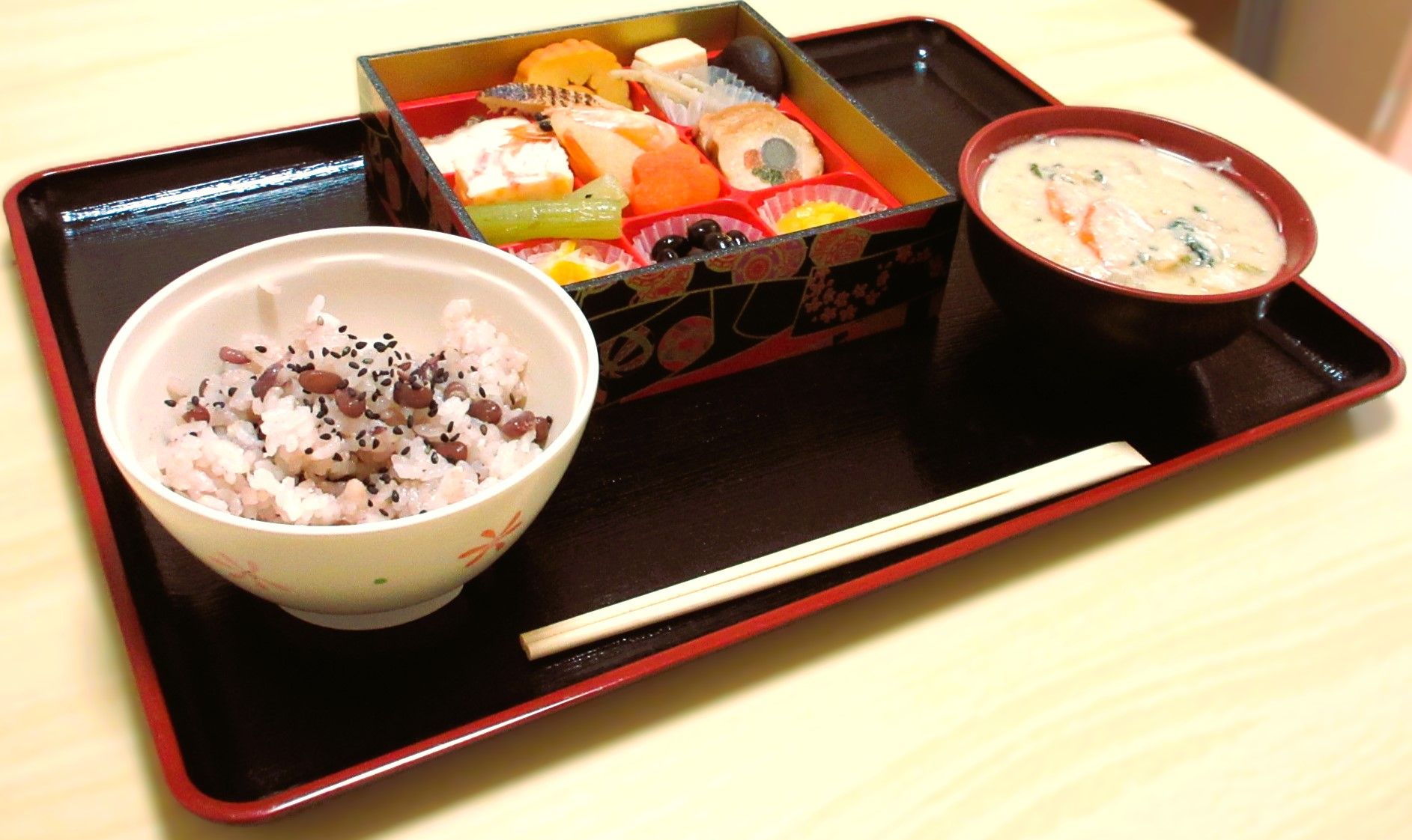 炊き上げた白米が茶碗に盛られている。その横には汁茶碗につがれた味噌汁が置かれている。そのほか、おかずが4種類用意されている。