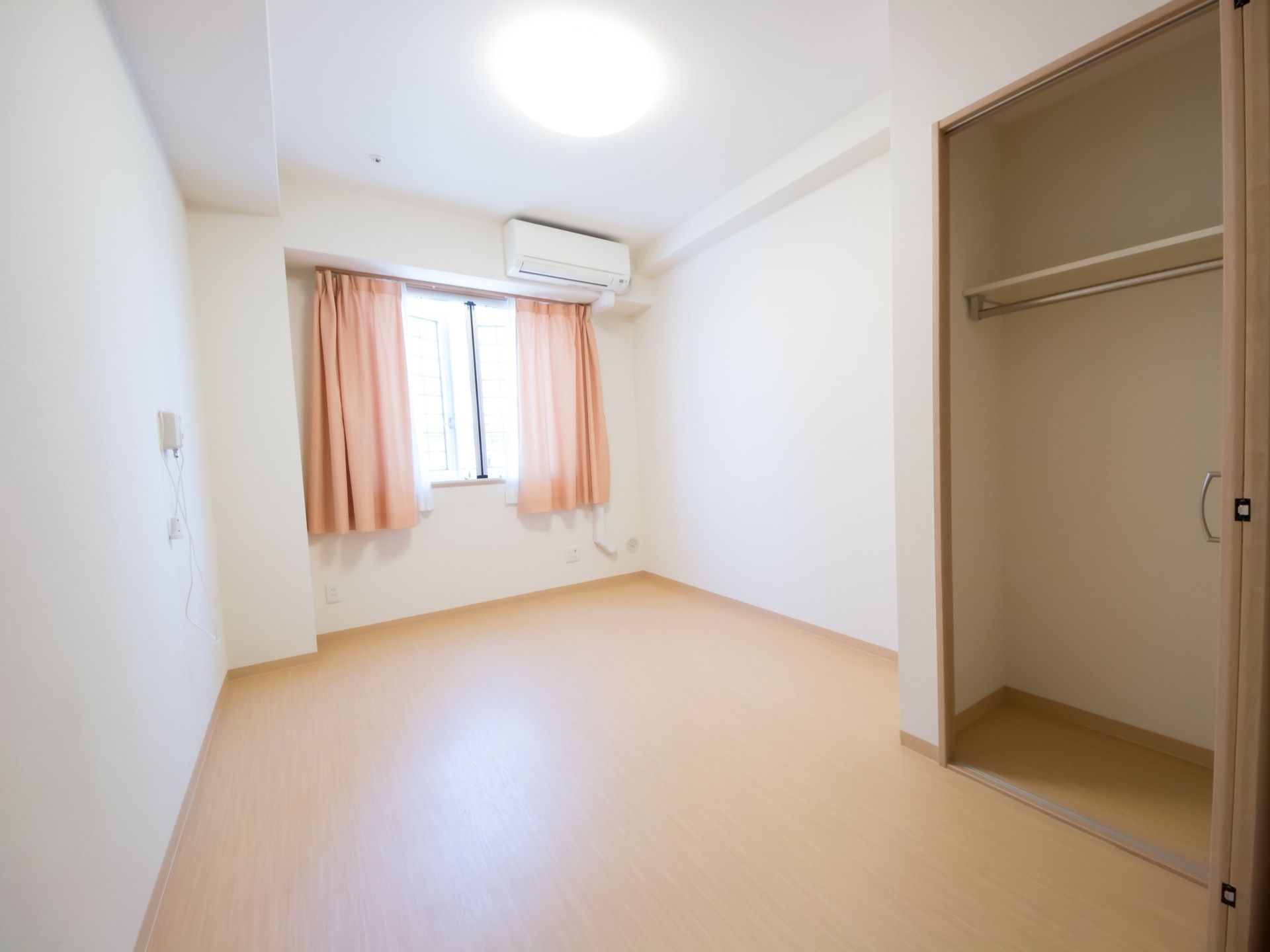 収納棚が広い居室になっている。窓とカーテンが付いており、温かな日差しが窓から差し込んでいる。空調設備も完備されている。