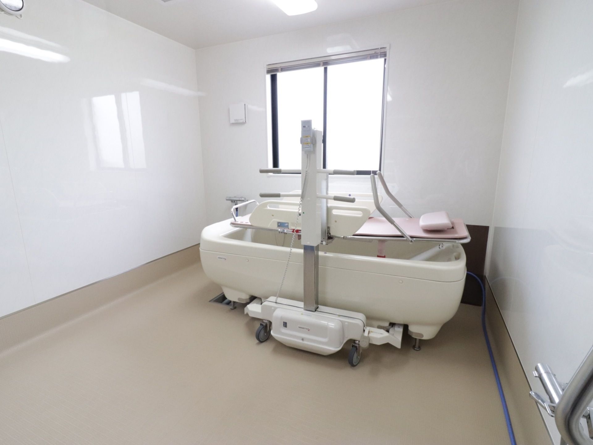 寝たまま入浴することができる設備がある浴室である。窓があり明るく、掃除が行き届いてあり清潔感がある。