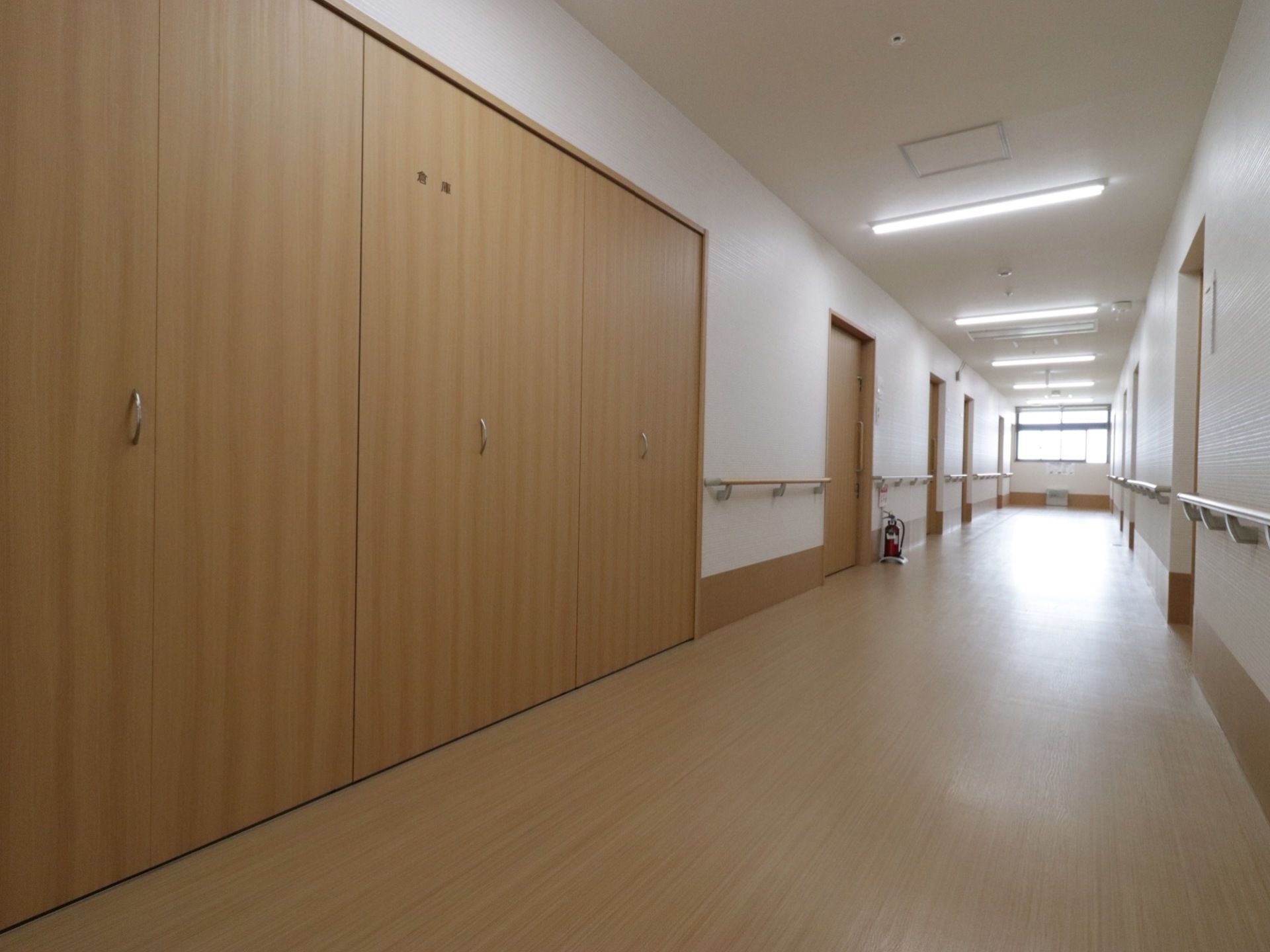 廊下には余計なものは置かず、広くすっきりとした空間を保っている。手すりはドアのすぐそばまで設置されている。