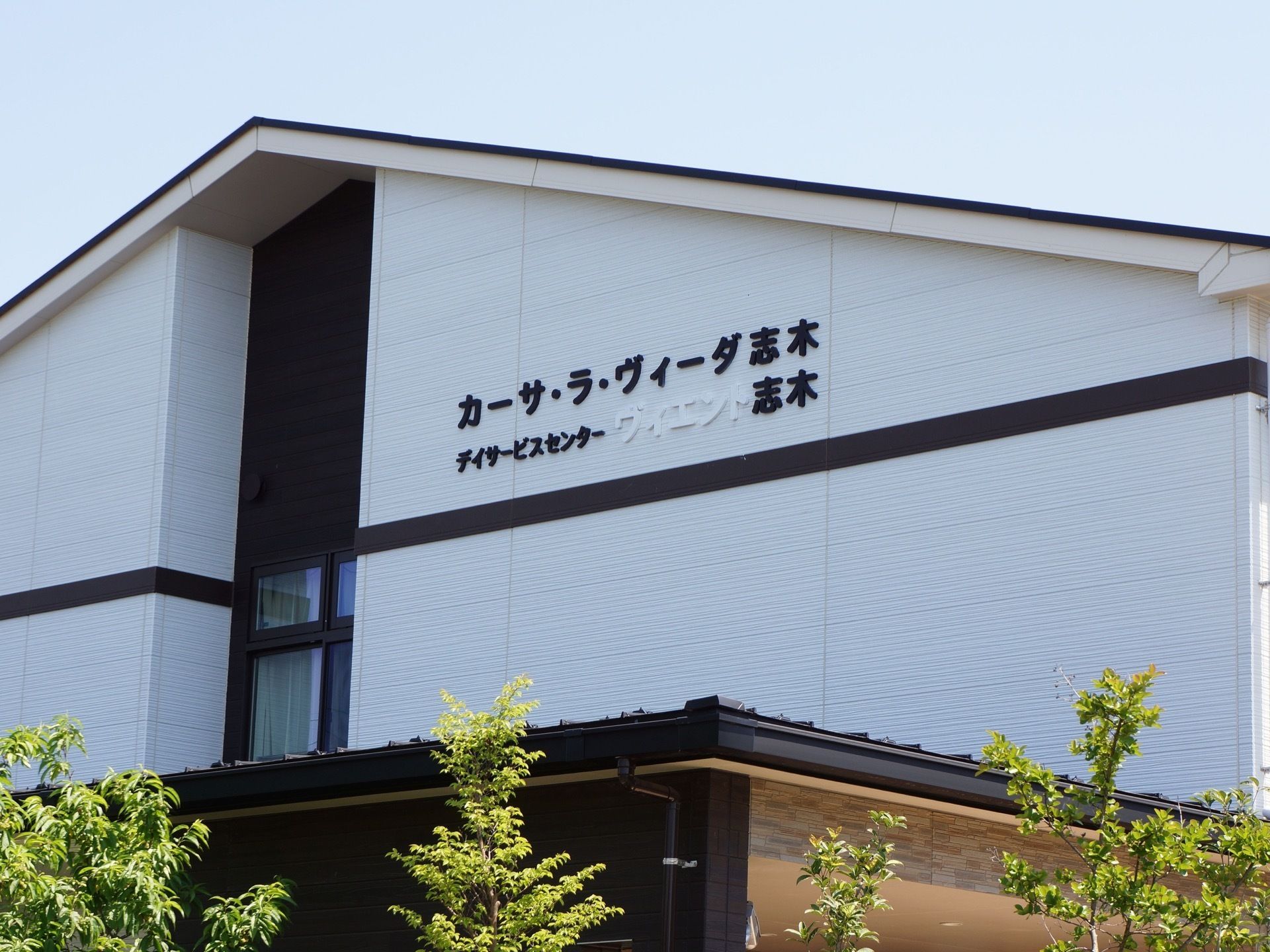 建物の外観の看板は車道側に面しているので、目印になる。白背景に黒い文字のシンプルな印象が特徴である。