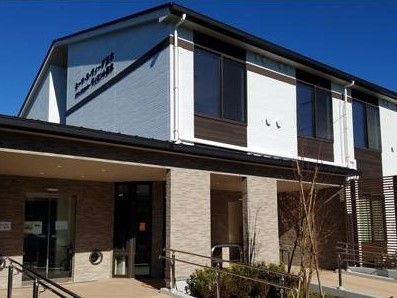 白色と茶色のツートンカラーの外壁を持つ、２階建ての施設外観