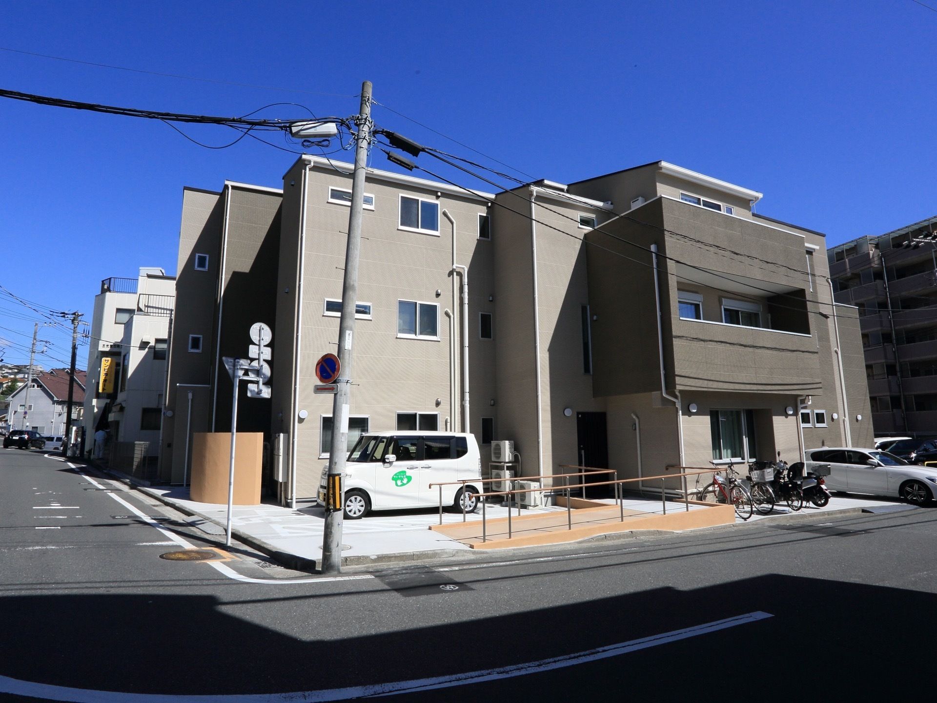 グレーを基調とした外観は、モダンで落ち着いた雰囲気である。敷地内には、数台の車が停められるスペースを設けている。