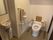 個室内に、背もたれや肘掛けの備わったトイレが設置されている。手洗い用の洗面台、跳ね上げ式の手すりも備わっている。