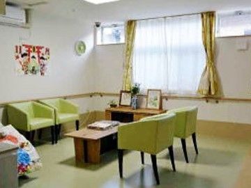 緑色のボックスチェアがローテーブルの周りに置かれている休憩スペース