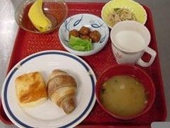 ２種類のパンと味噌汁、ミートボールと和え物、デザートがトレーに乗っている。飲み物はパンに合わせて、牛乳が用意されている。