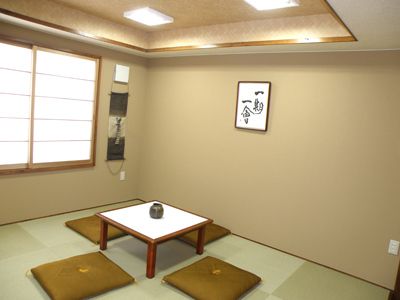 畳敷きで、小さなテーブルの周りに座布団が４枚置かれている和室