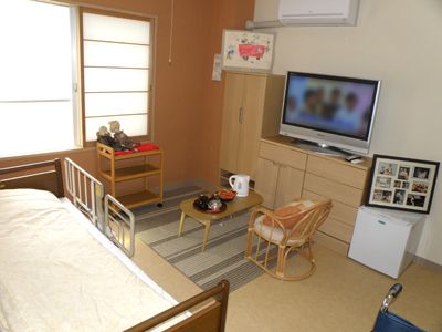 ちゃぶ台の上に電気ポットや湯呑などが置かれている居室