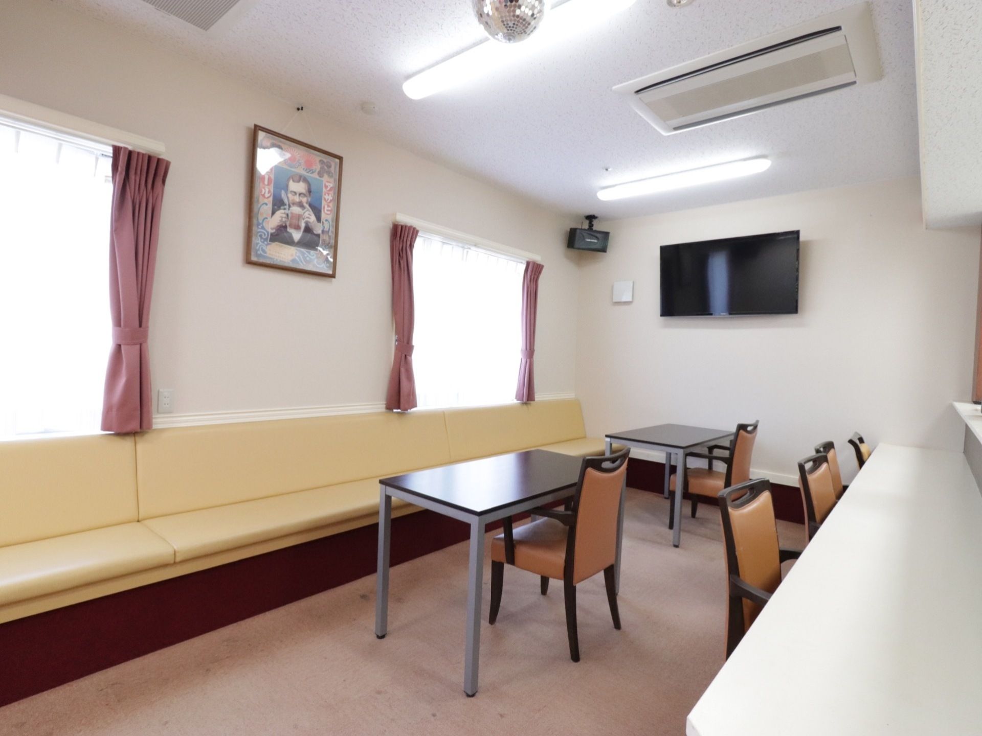 壁にソファが備え付けられており、テーブルと１人掛け用の椅子が向かい合わせに置かれている。カウンター席もある。