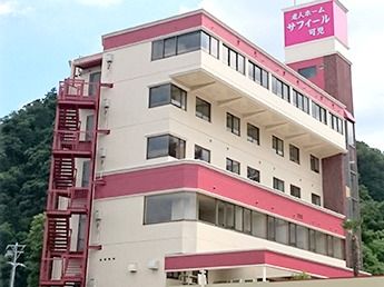 最上部にあるピンク色の看板に、白色の文字で施設名称が書かれている施設外観