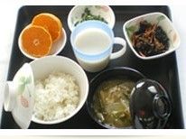 ご飯、味噌汁、副菜に、デザートの輪切りのミカンを添えた献立