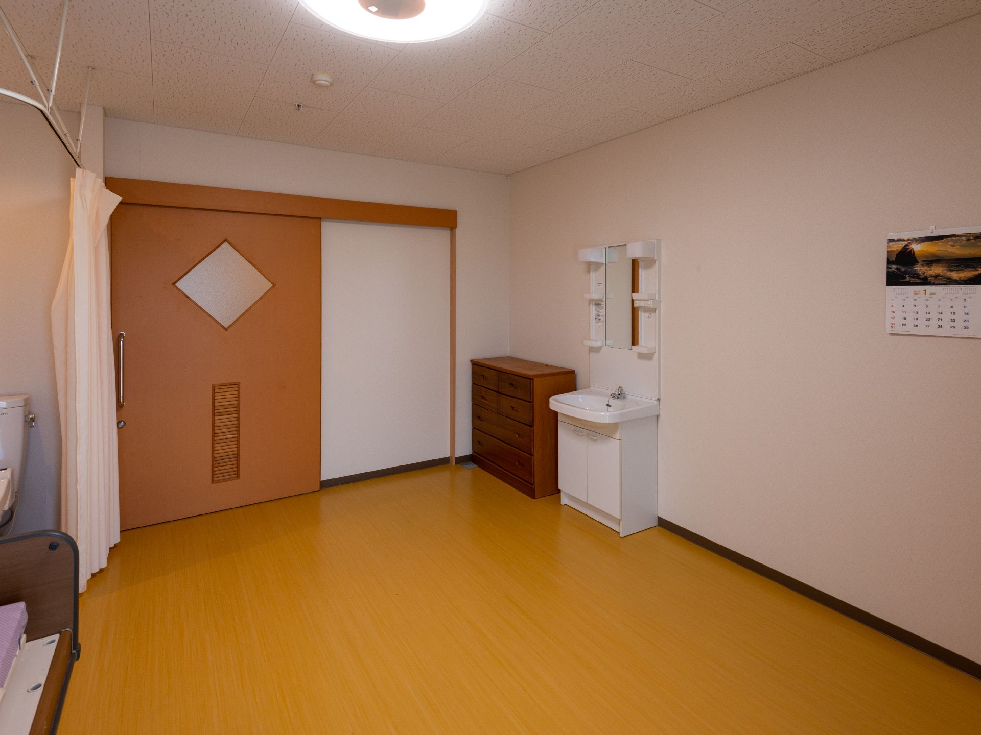 家具や介護ベッドが落ち着いた色になっている居室
