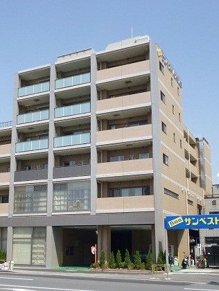 道路に面して建っていて、一部のバルコニーの外壁の色が他とは違っている施設外観
