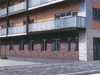 居室のバルコニーに半透明の目隠し板が設置されている施設外観