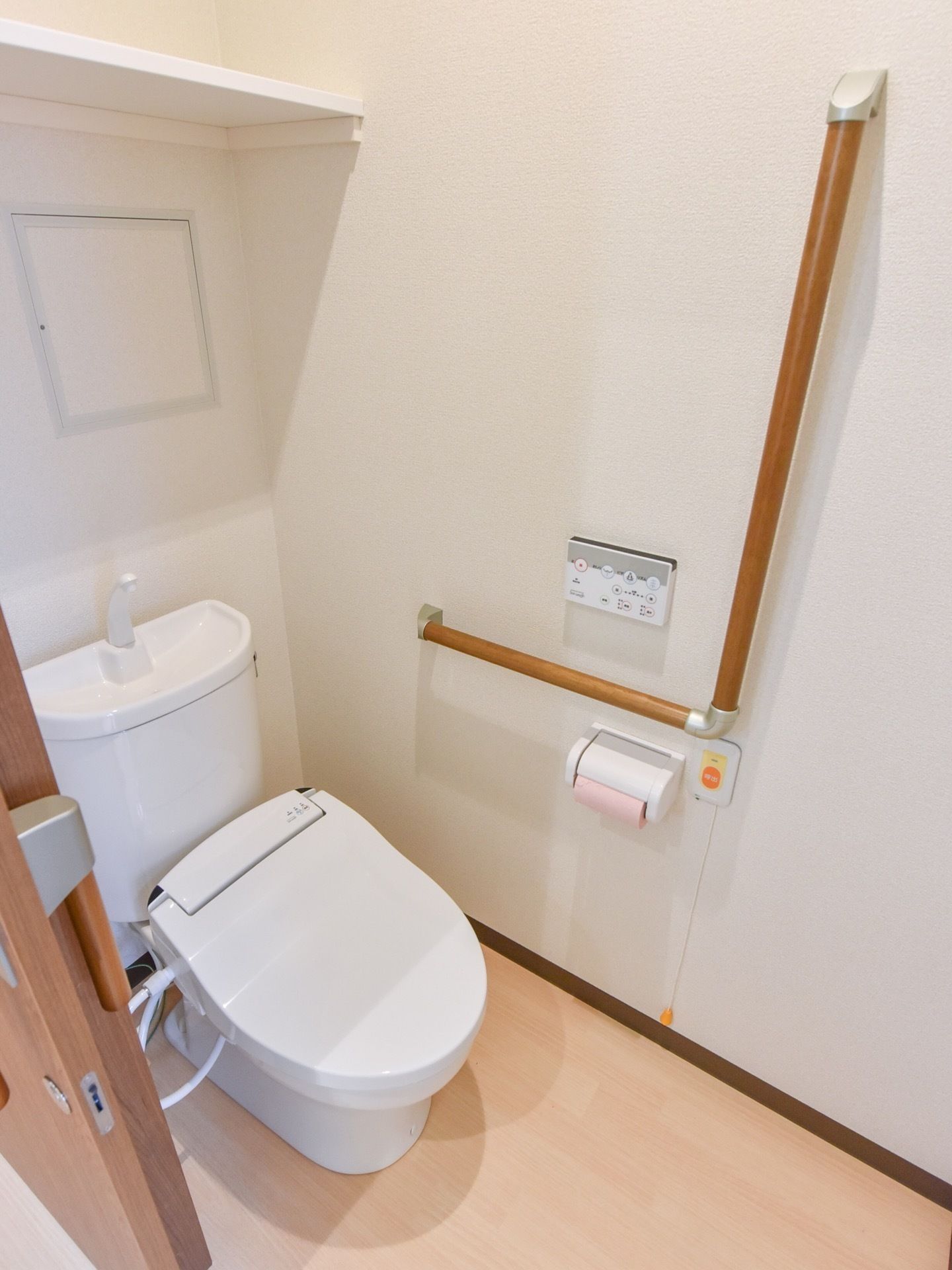 トイレには天井近くに棚が１段作りつけられている。温水洗浄便座を使用しており、操作は壁のパネルで行う。