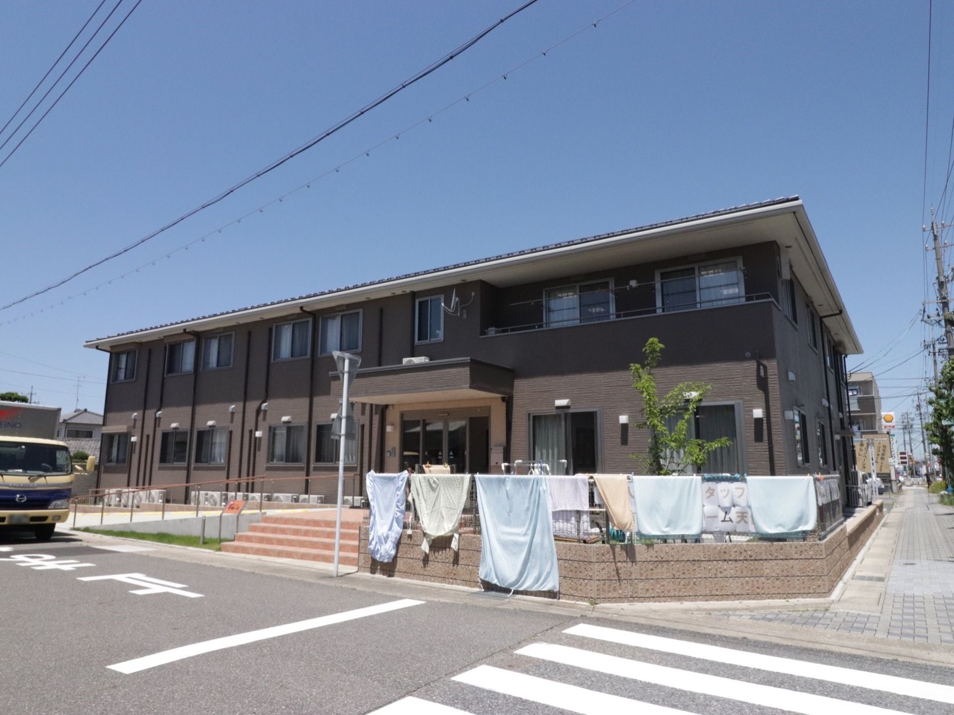 道路に面したところに立地している。ダーク系の建物で落ち着きがある。フェンスを使って洗濯物が広々と干されている。