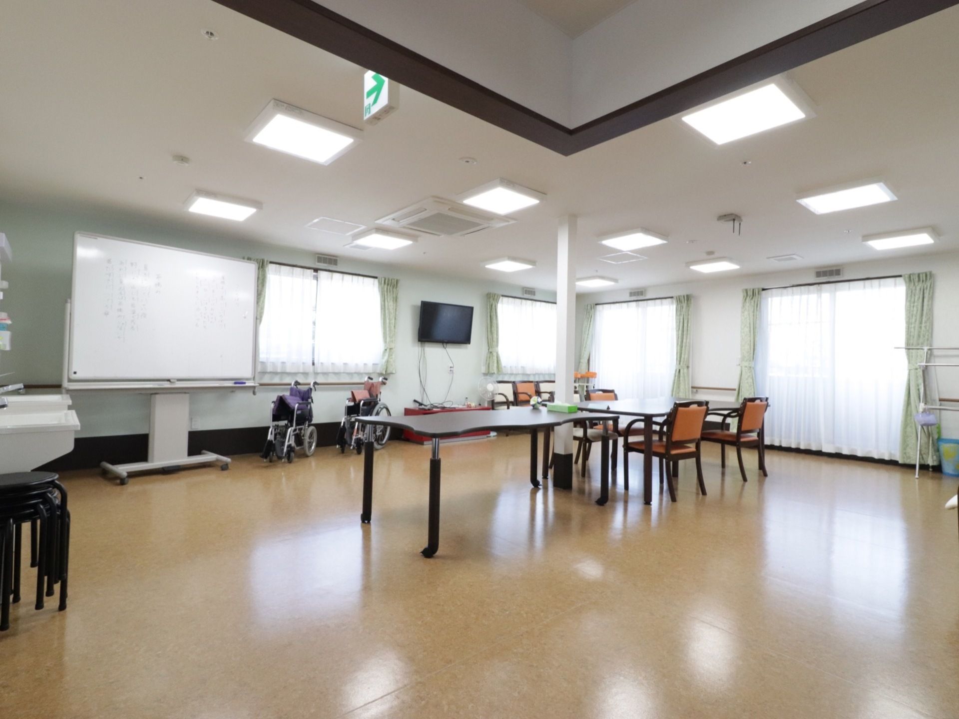窓が複数設置され、自然光をたくさん取り込む設計になっている。壁側に大きなホワイトボード、すぐそばには車椅子が置かれてある。