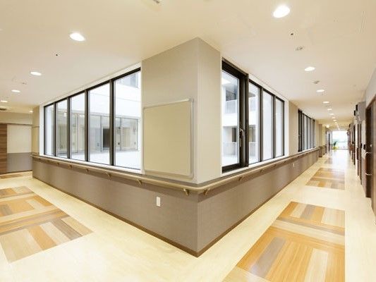 ゆったりとした広さの、明るく美しいデザインの廊下である。窓側には手すりが備えられており、安心して利用できる。