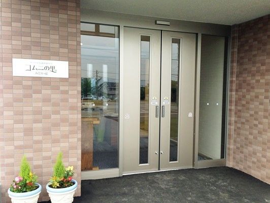 段差がない玄関は、触れると開く自動ドアなので、スムーズに出入りがしやすい。玄関脇には、かわいい植木鉢がある。