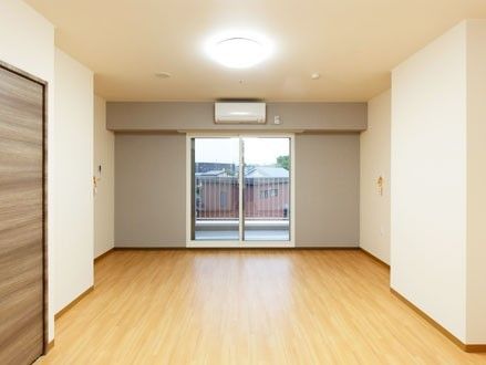 アイボリーの壁とフローリングが美しく、収納もある部屋である。大きな窓からはベランダにも出ることができる。