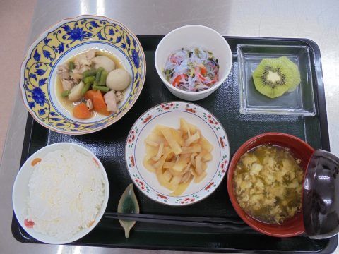 ご飯に汁物、煮物、副菜が２種類つき、デザートのフルーツも添えられている。栄養のバランスがとれた食事である。