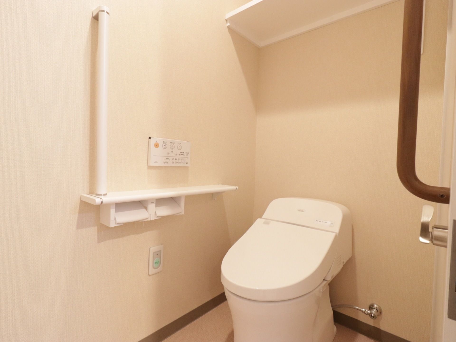 トイレは洗浄機能付きで、タンクはない。両脇に手すりを配し、ペーパーホルダーは2つある。上部には棚があり、物が置ける。