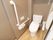 フローリングの床の上に便座が設置されている。トイレの便座に座ると、左右それぞれに手すりがあり、安全に利用できる。
