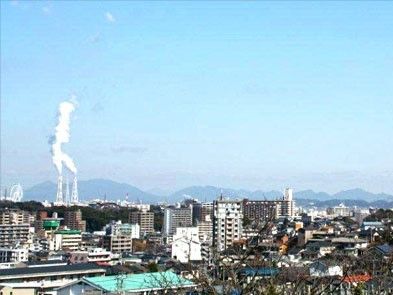青空の下に家々の屋根や工場の煙突など、下町ののどかな風景が広がっている。遠くには長く連なる山々も見渡せ、懐かしい気分に浸れる。