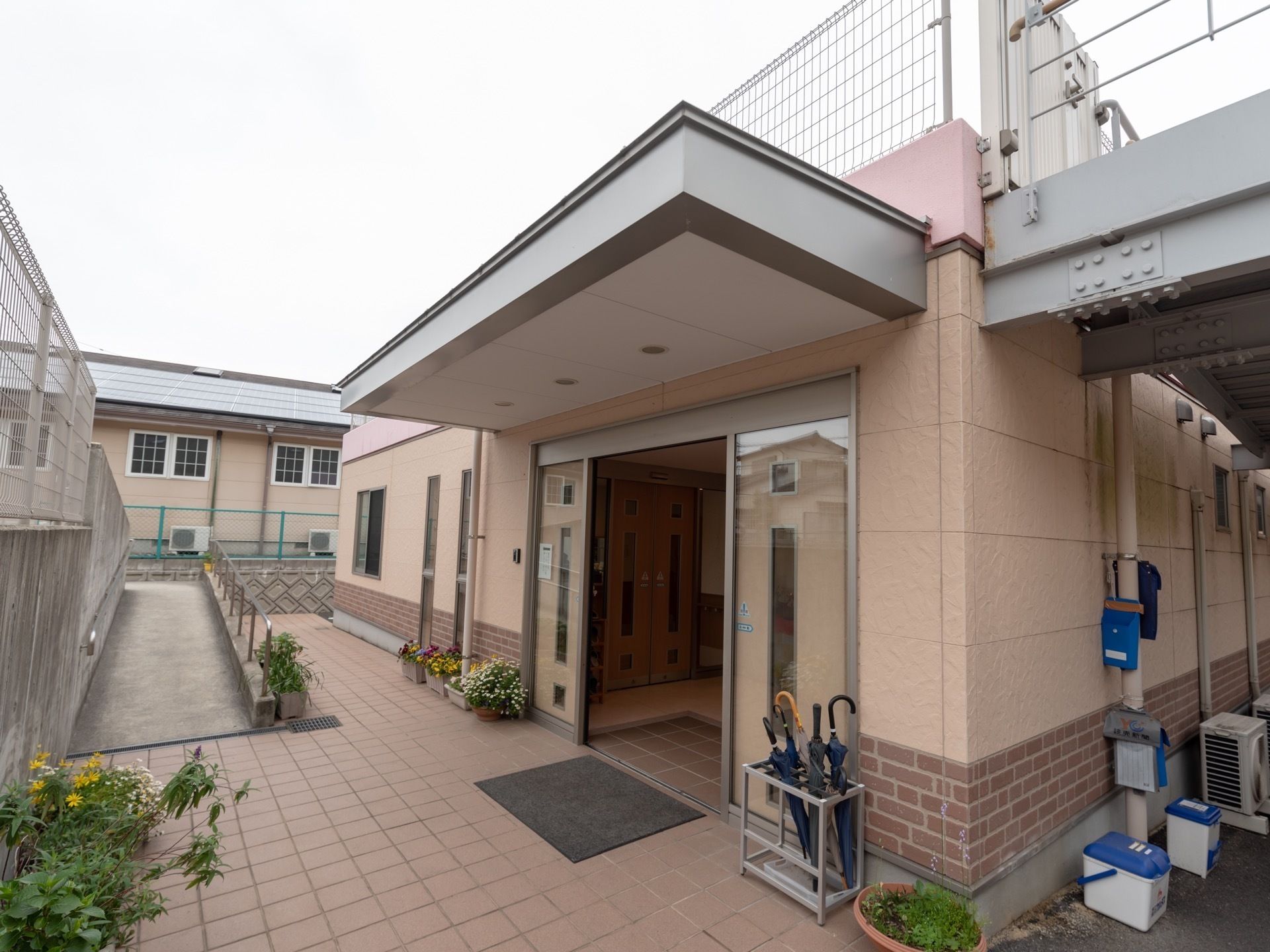 道路から手すりがついたスロープで下ってきた場所にある施設玄関