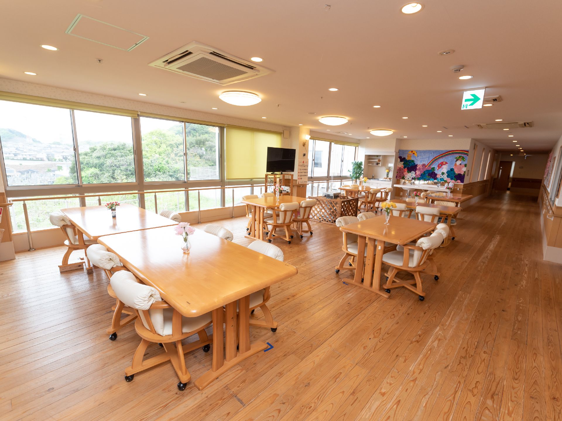 スクリーンが下ろされている窓の手前にテレビが置かれている食堂