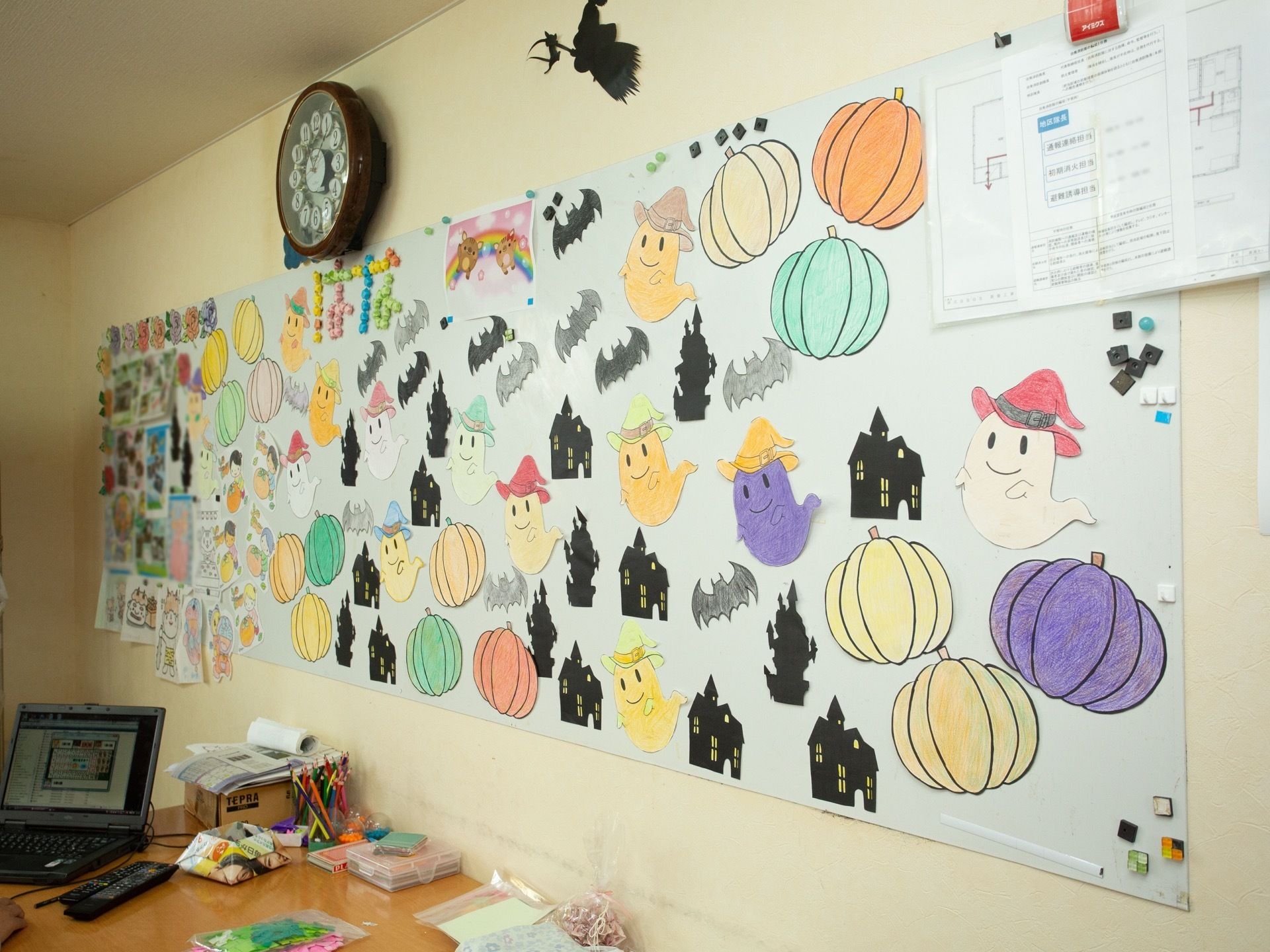 デスクの上に大きなマグネットボードが貼ってある。季節のイベントに関連したイラストや情報共有のための書類を掲示している。