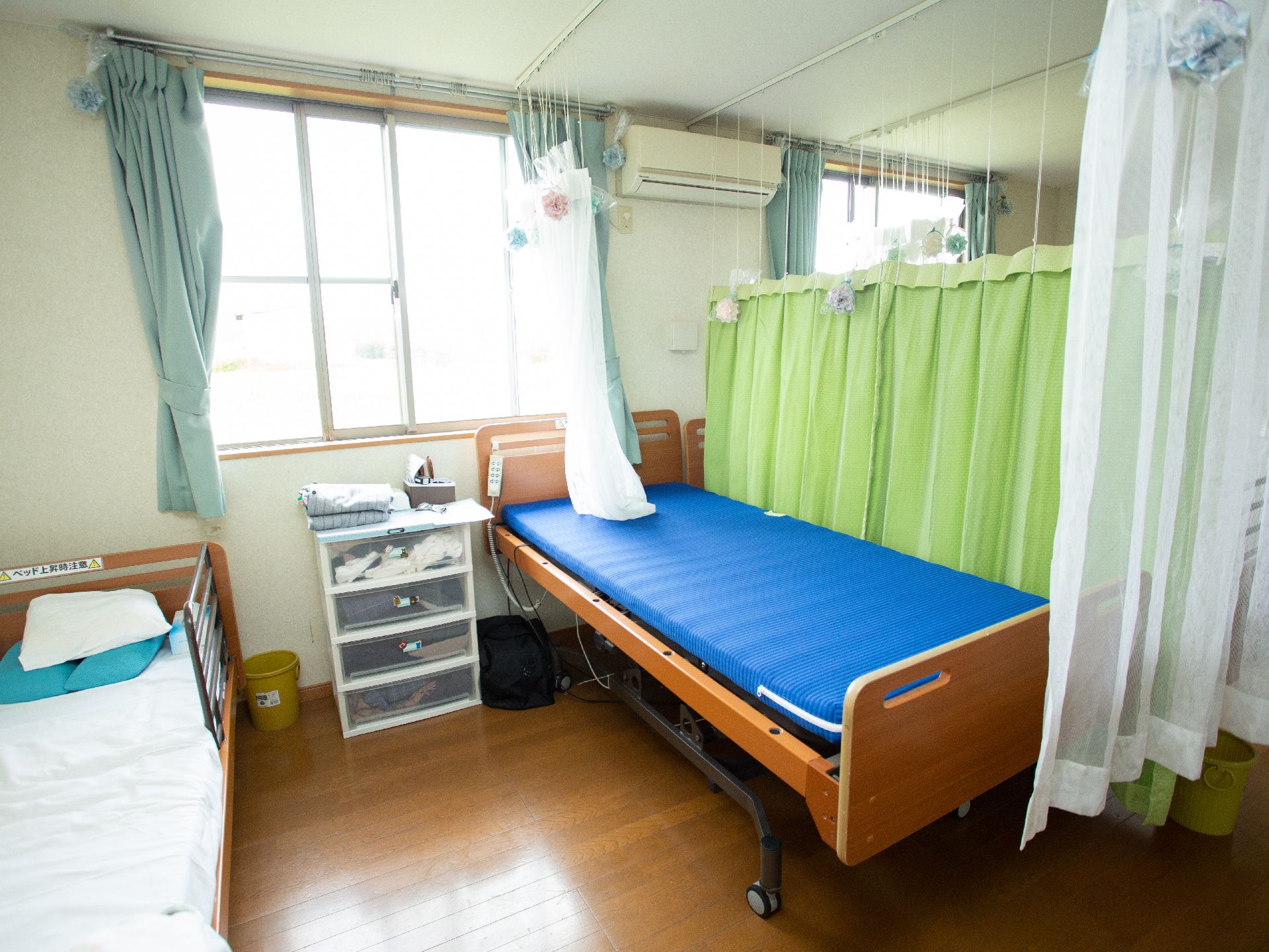 カーテンで仕切ることができるようになっている場所にベッドが置かれた医務室