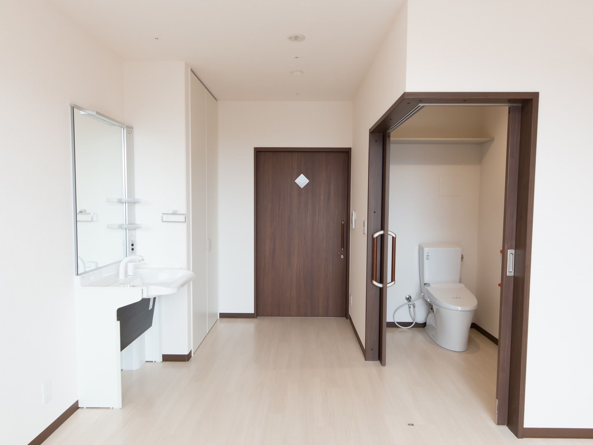 シンプルな居室。トイレの扉は２方向からＬ字型に開くようになっており、車椅子をご利用の方もストレスなく出入りすることができる。